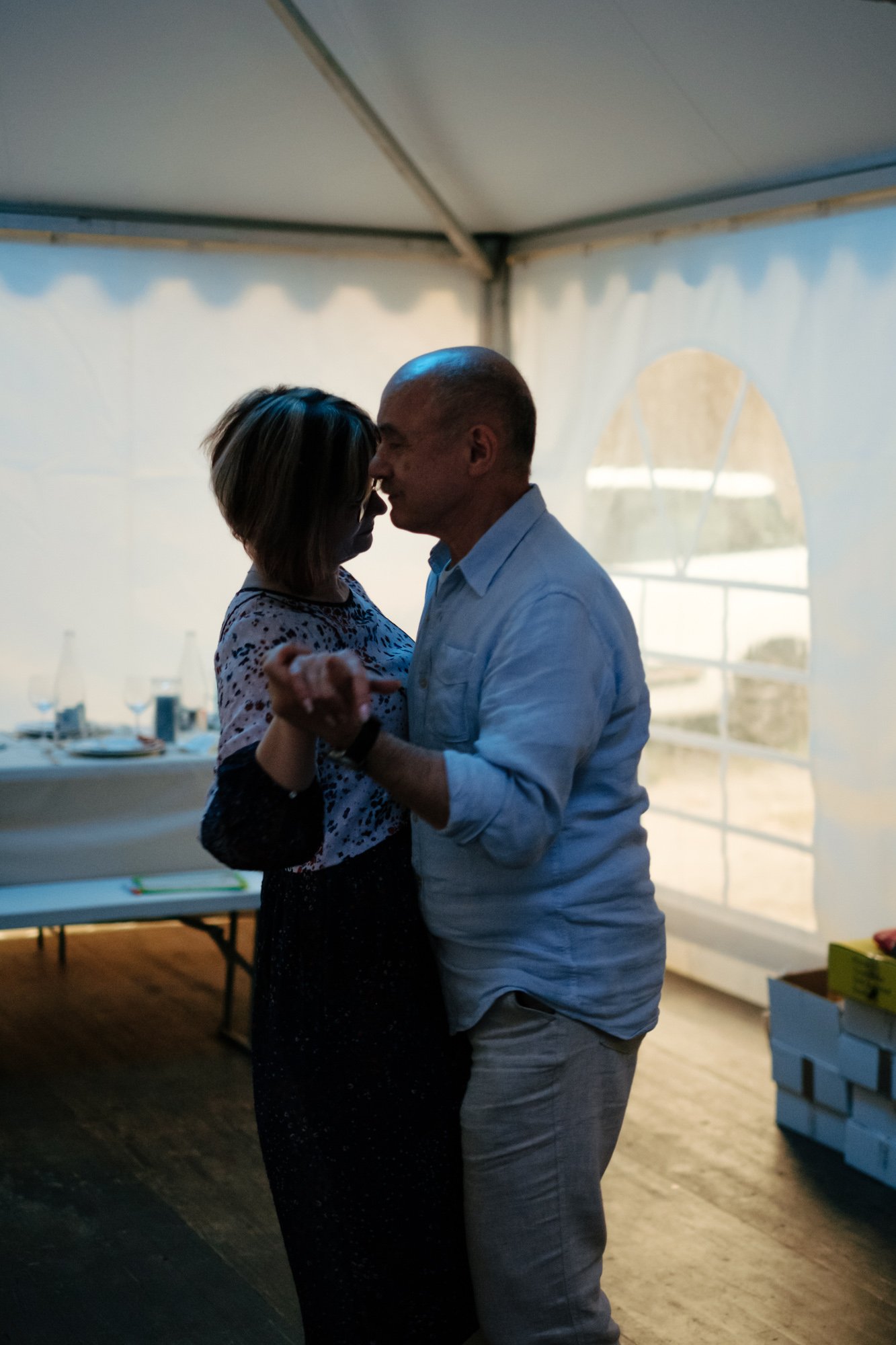 Un couple danse dans une tente avec une lumière douce qui créée une silhouette.