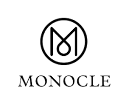 Logo de Monocle avec un symbole circulaire et le nom 'MONOCLE' en dessous.