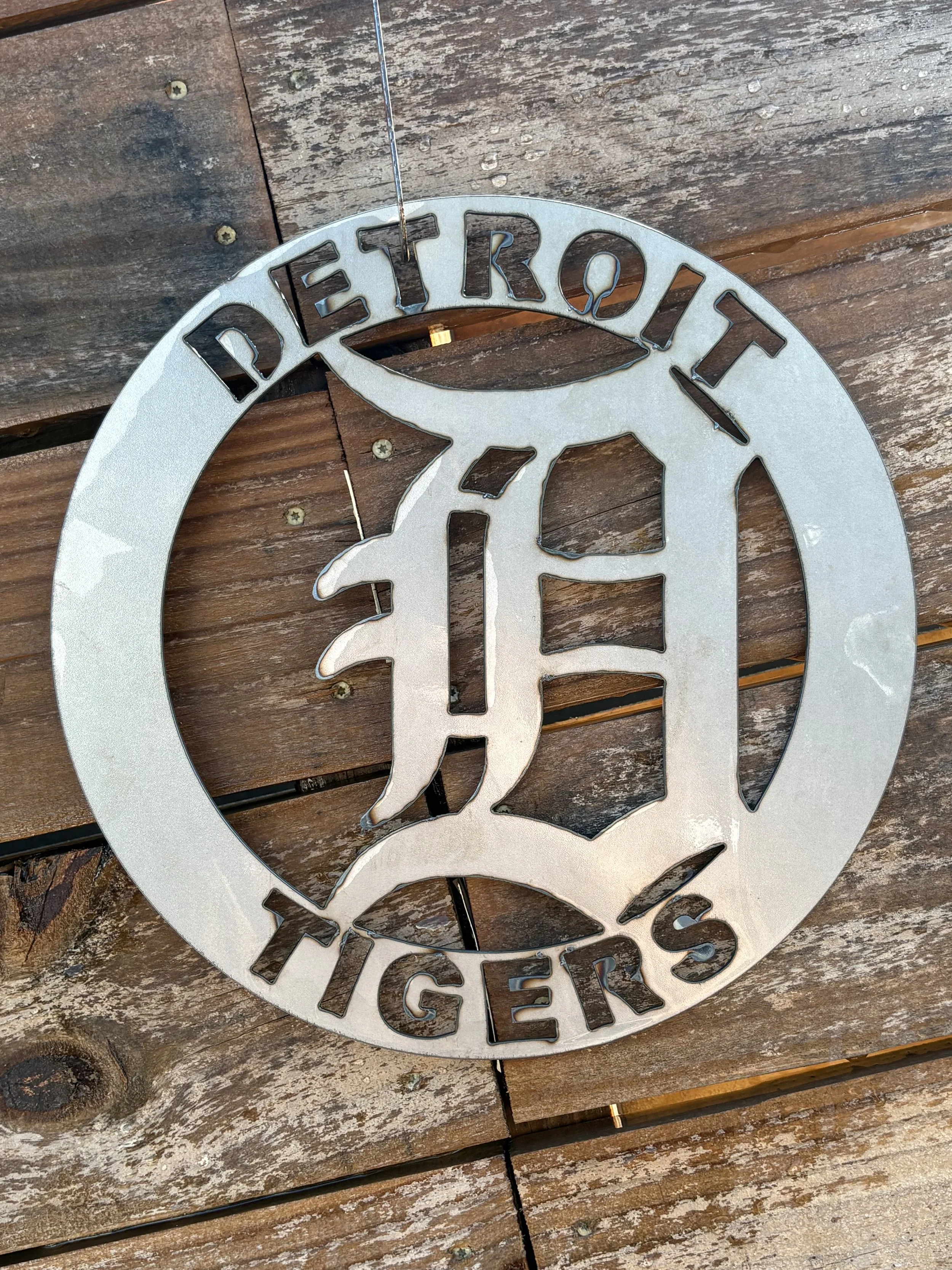 Metal Detroit Tigers logo wall sign on wooden background.