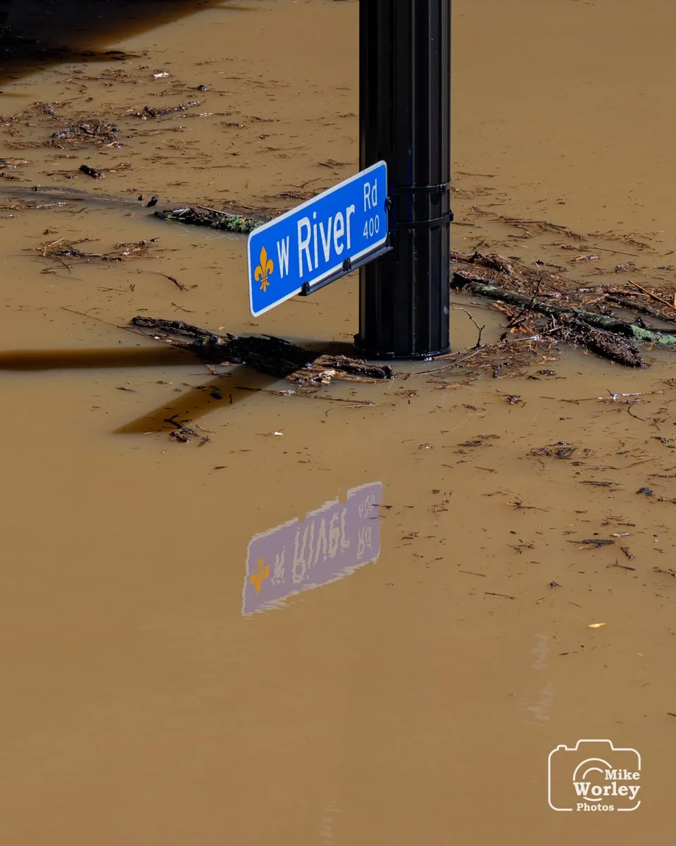Street sign showing a flooded River Rd during the 2025 waterfront flood