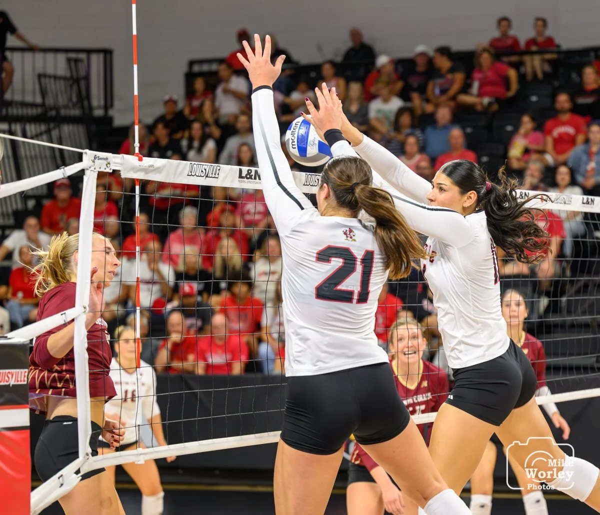 Payton Petersen (21) and Hannah Sherman block an attack back to the floor