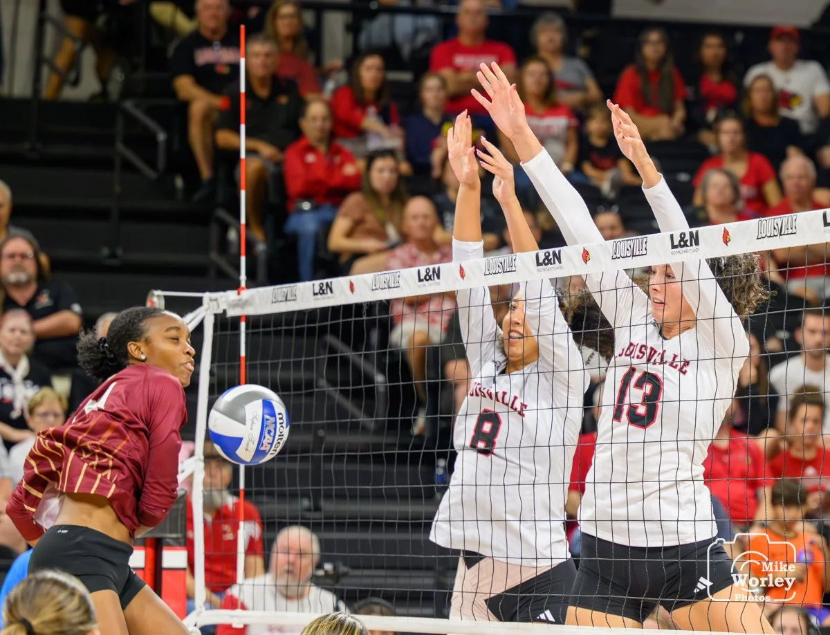 Nayelis Cabello (8) and Cara Cresse (13) smile as they block a ball to the floor