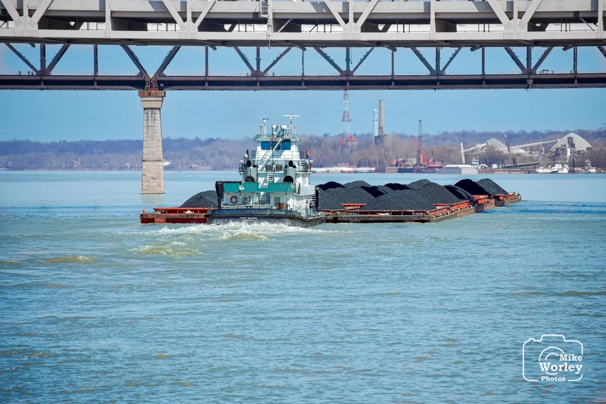 A tugboat pushes barges loaded with coal up the Ohio River