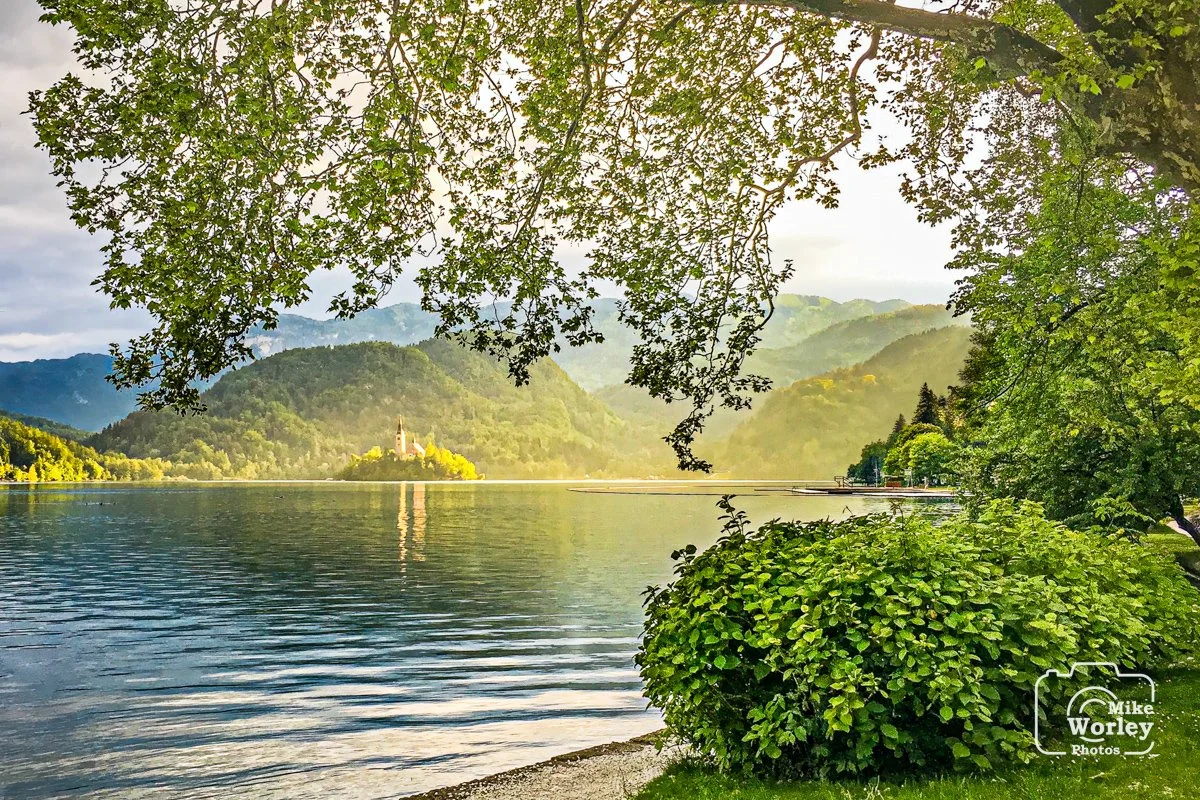 Lake Bled at sunset with Bled Island visible in the center. The church on Bled Island dates from the 1400s and is an international wedding destination.
