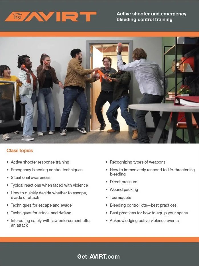 A group of people participating in a simulated active shooter training session, with some acting as victims and others as responders, in an indoor training room.