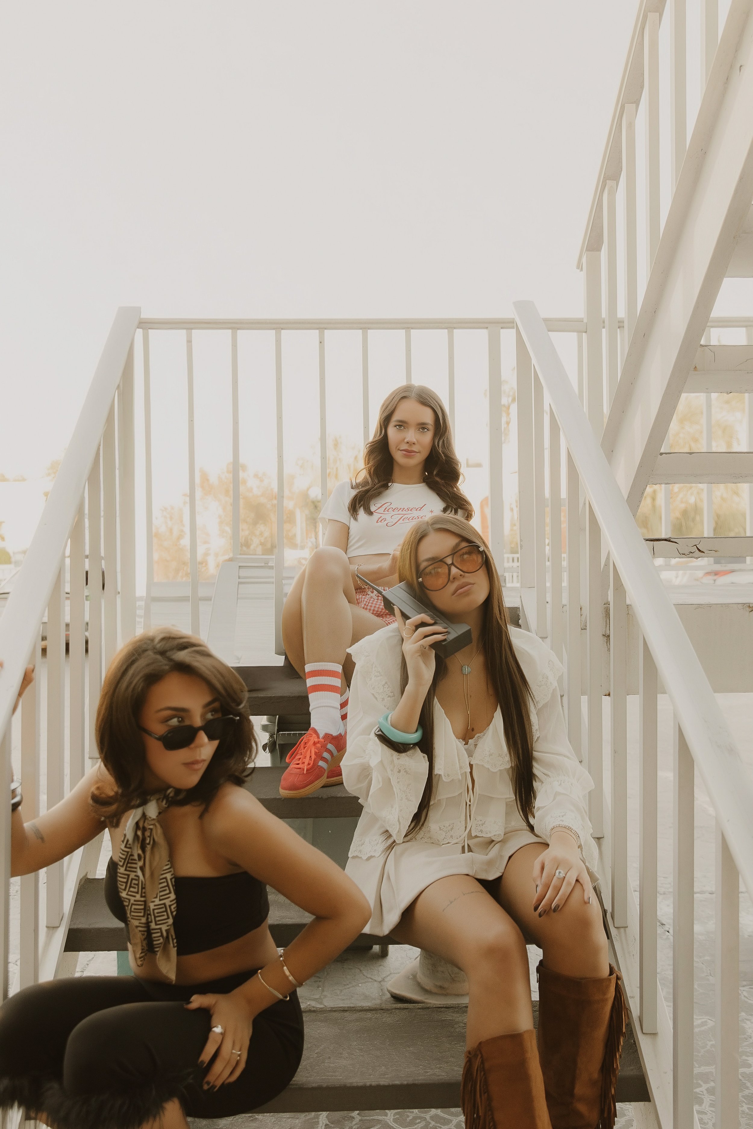 three gorgeous women at stairs of motel western boots and pin up style hair and make up cute sunglasses big hair