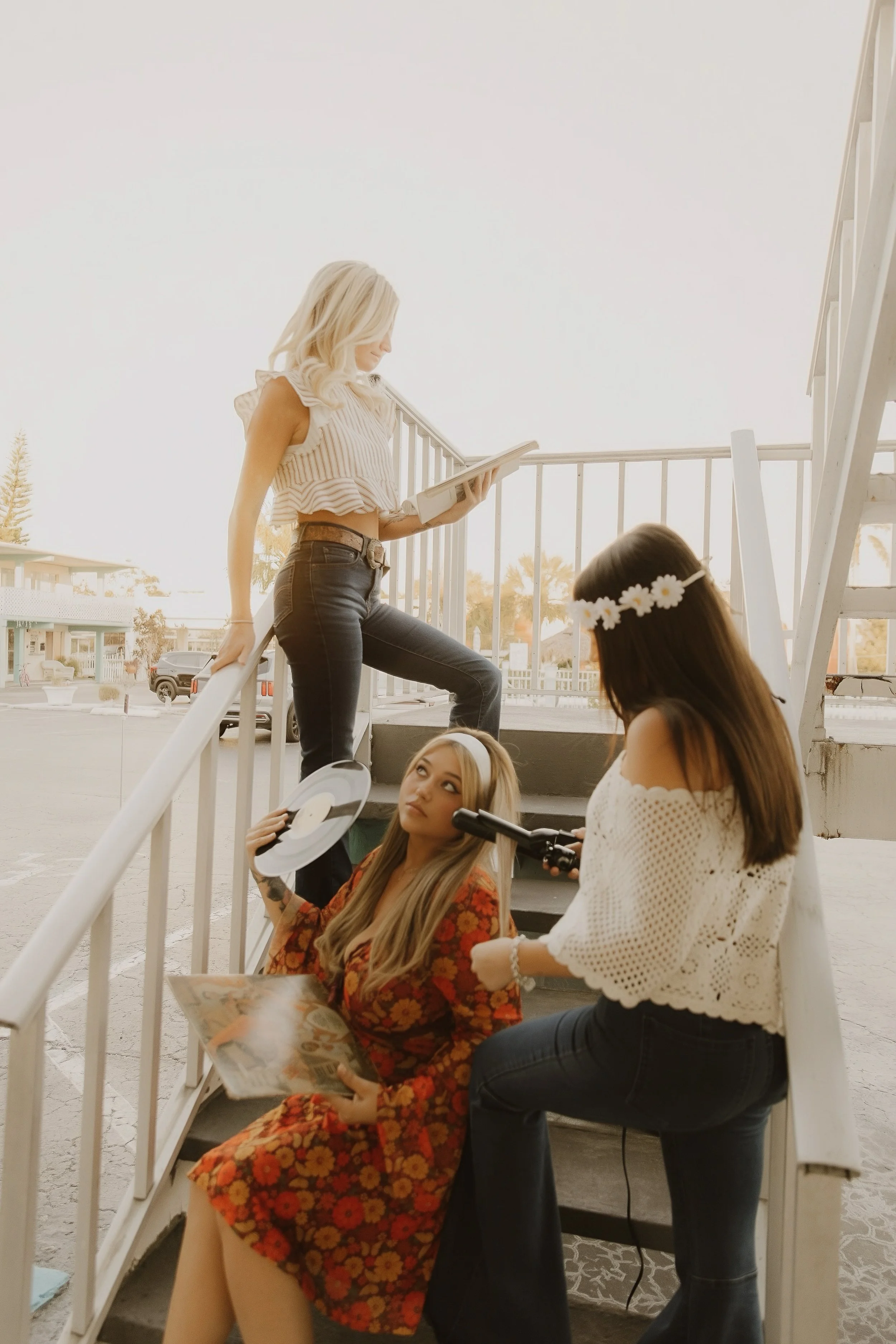 3 women 70s style hanging at the stairs of motel glamorous fresh blowouts