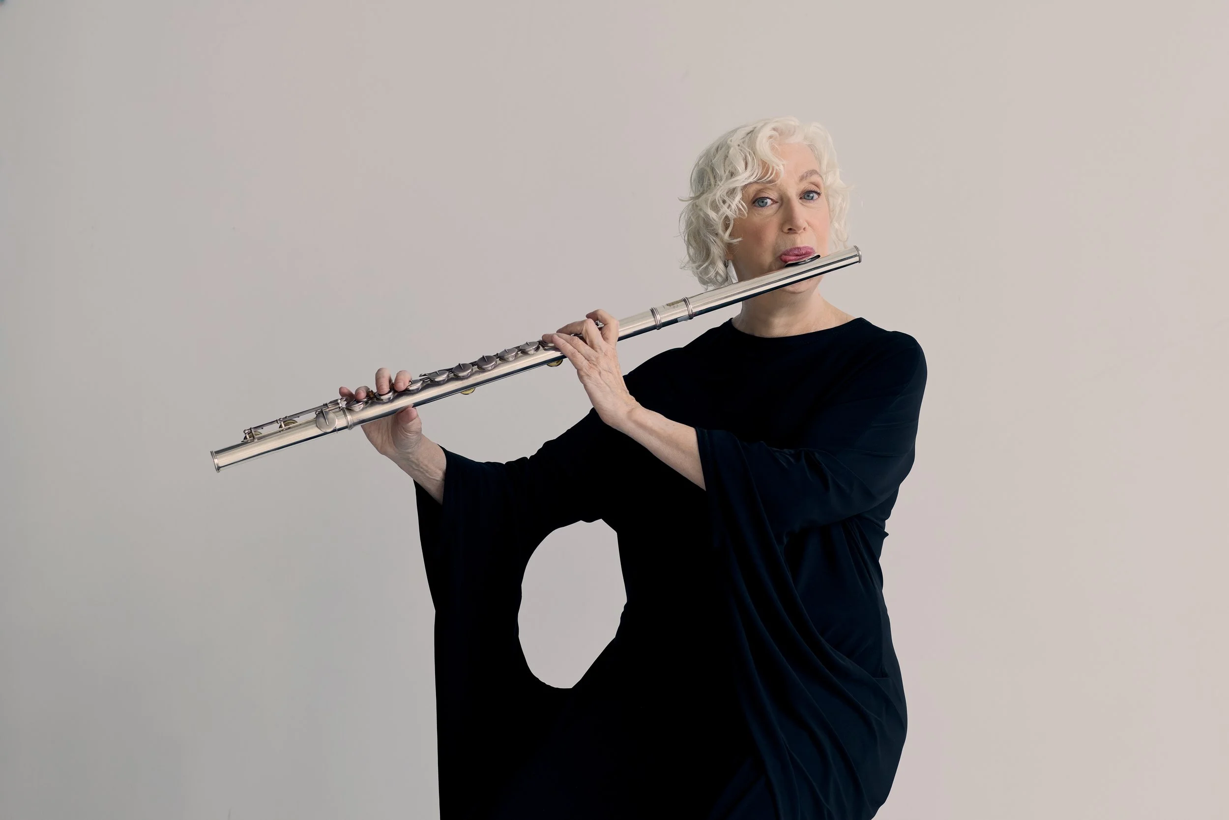 Wendy Stern, performer and educator, wearing a black dress and playing an alto flute