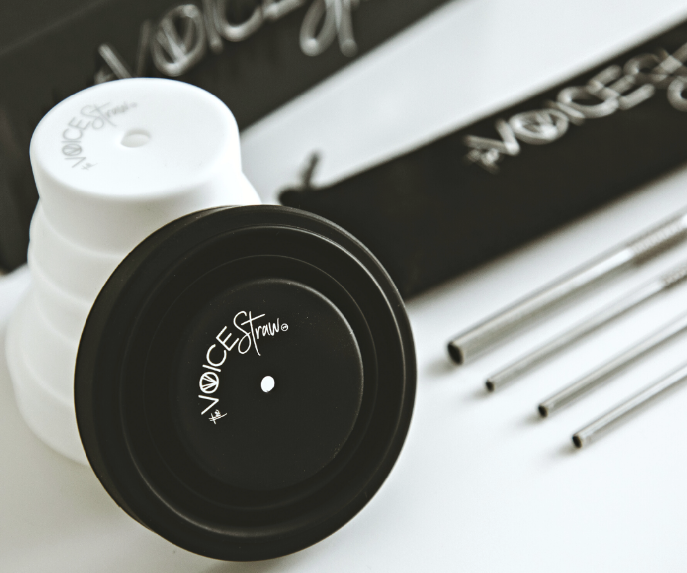 Stainless-steel vocal exercise straws with black and white bottle adapters.
