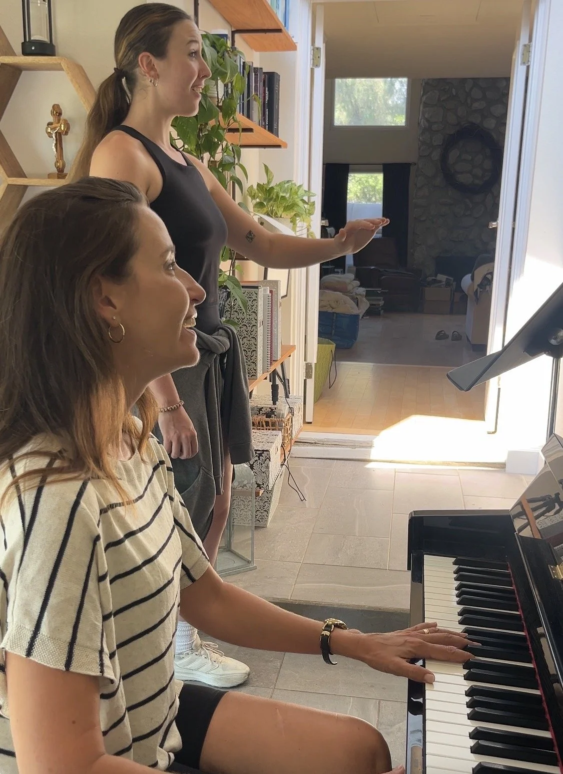 Voice teacher accompanies a singer at the piano during a private singing lesson.