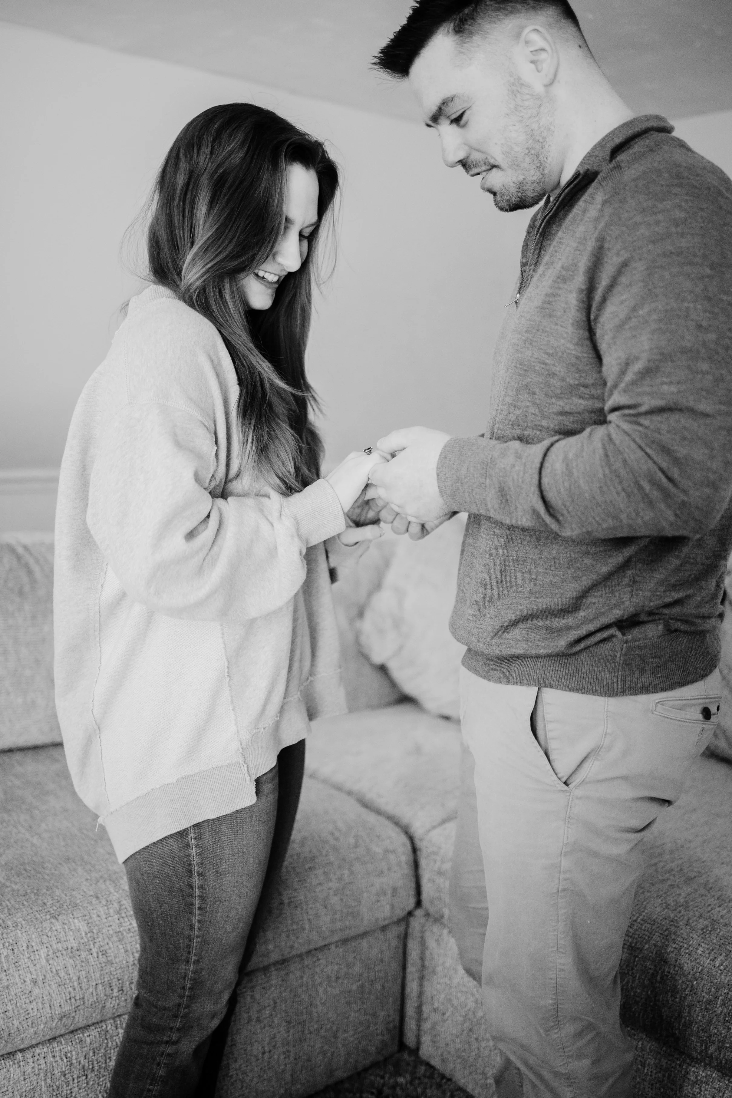 A man is proposing marriage to a woman in a living room.
