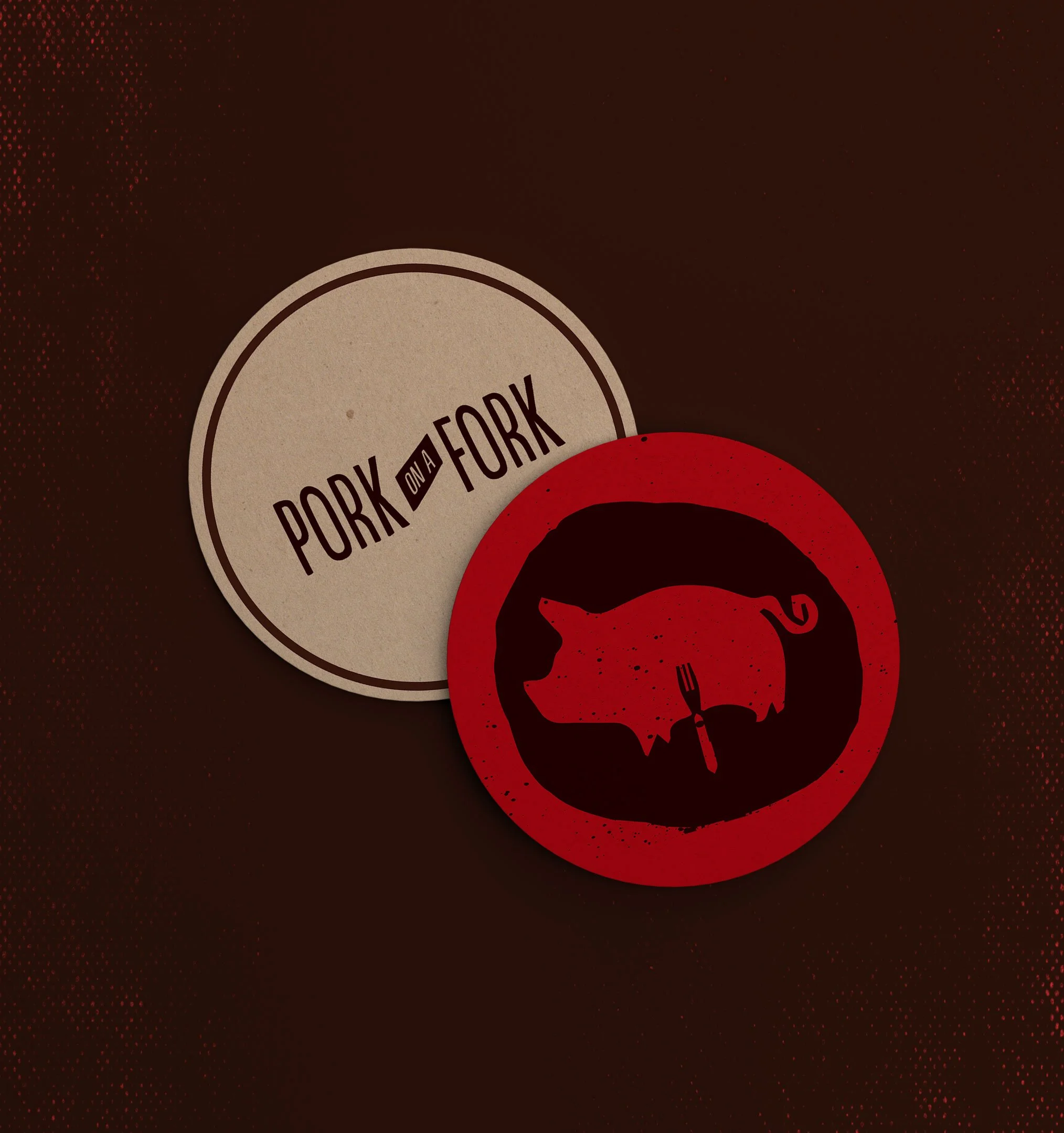 Close-up of a dark brown and red design with a beige circular label reading 'Pork on a Fork' and a red pig silhouette logo.