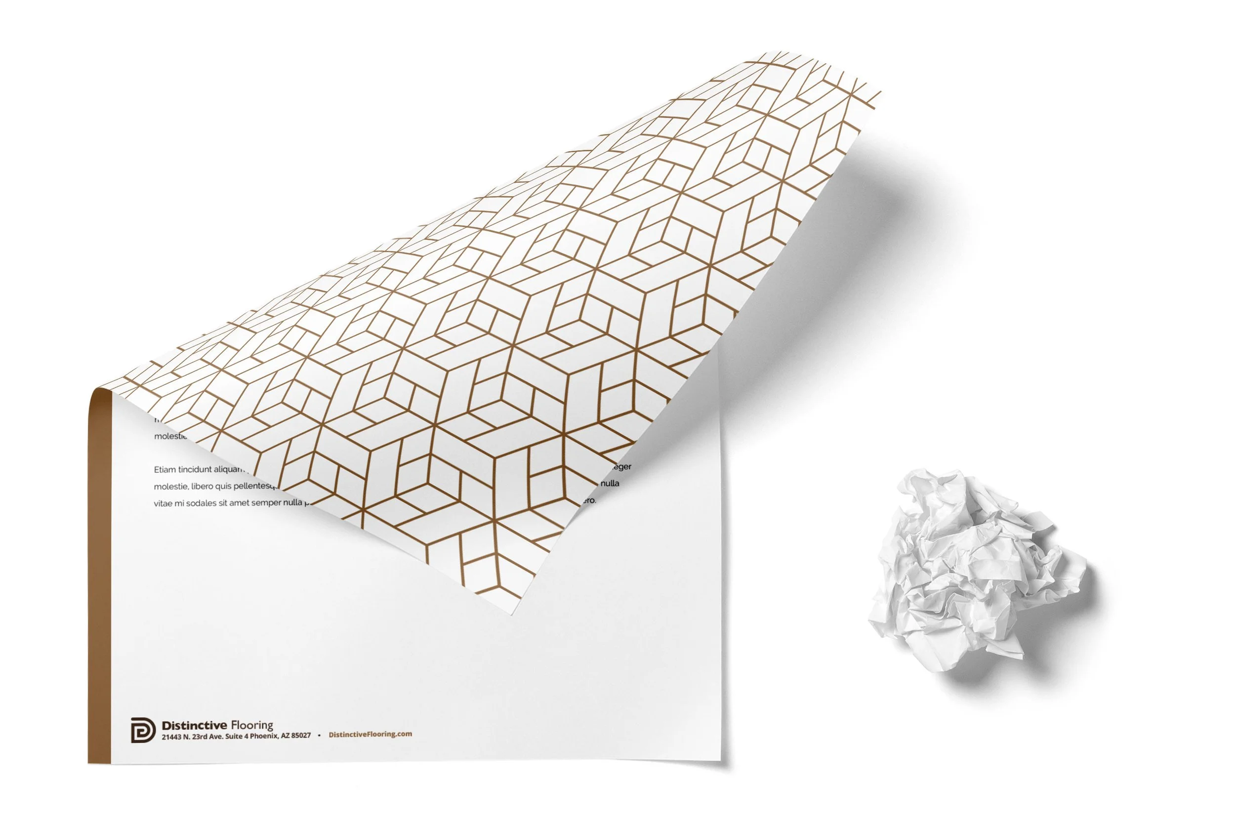 A sheet of patterned flooring sample with a geometric design in brown lines on white background, along with crumpled paper and printed text partially visible at the bottom.