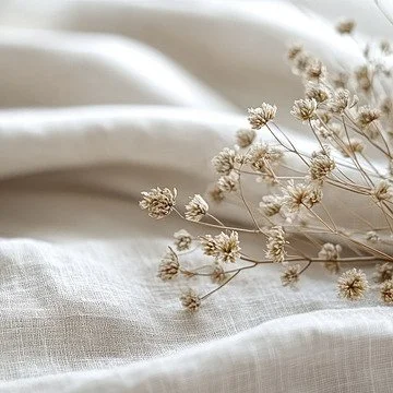Dry white flowers on soft, light fabric.