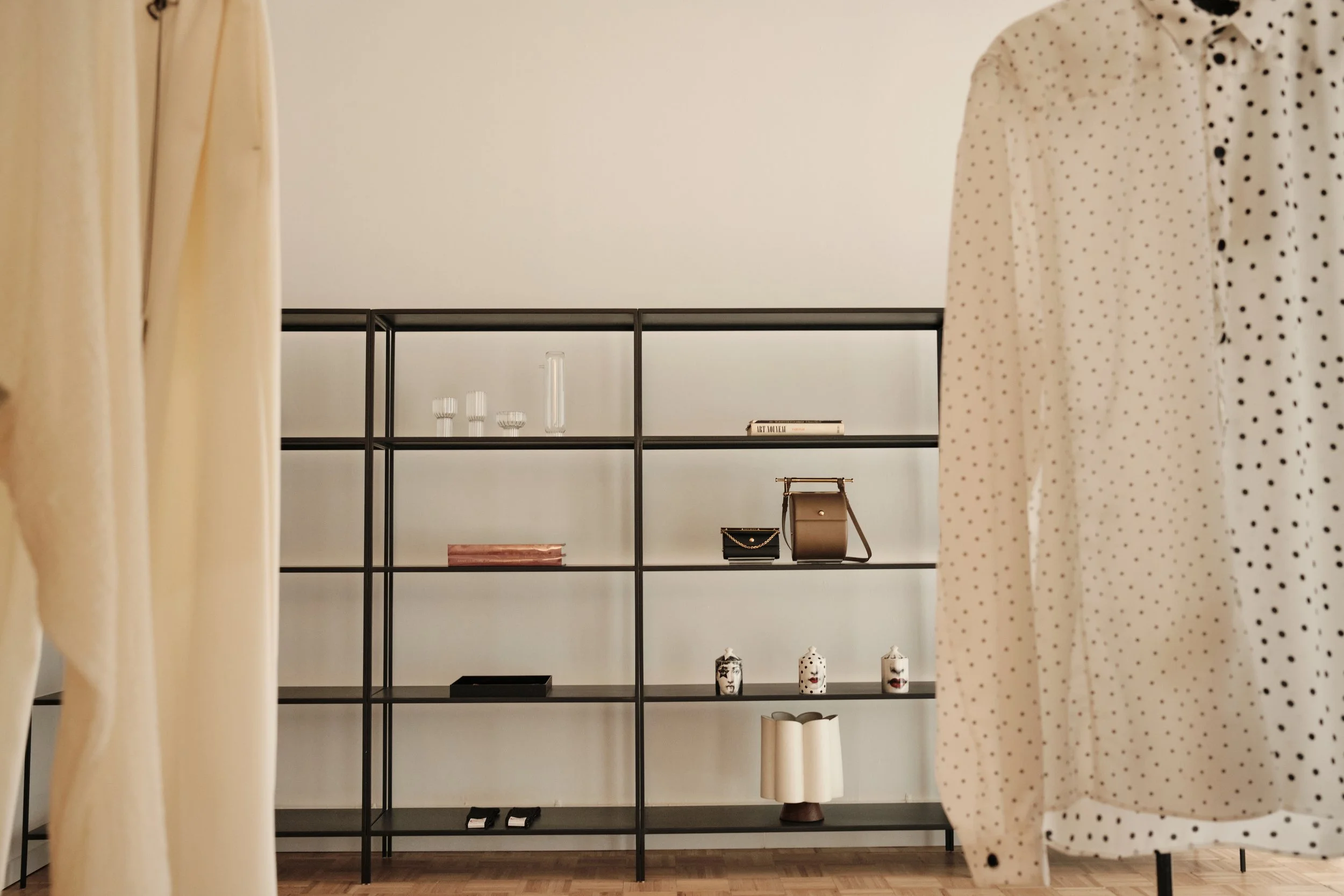 soft light still life photography in retail space focused on products on shelving. luxury hand bags vases and glassware sit on the shelfs of New York City luxury retail space within a classic tribeca loft. interior design photography