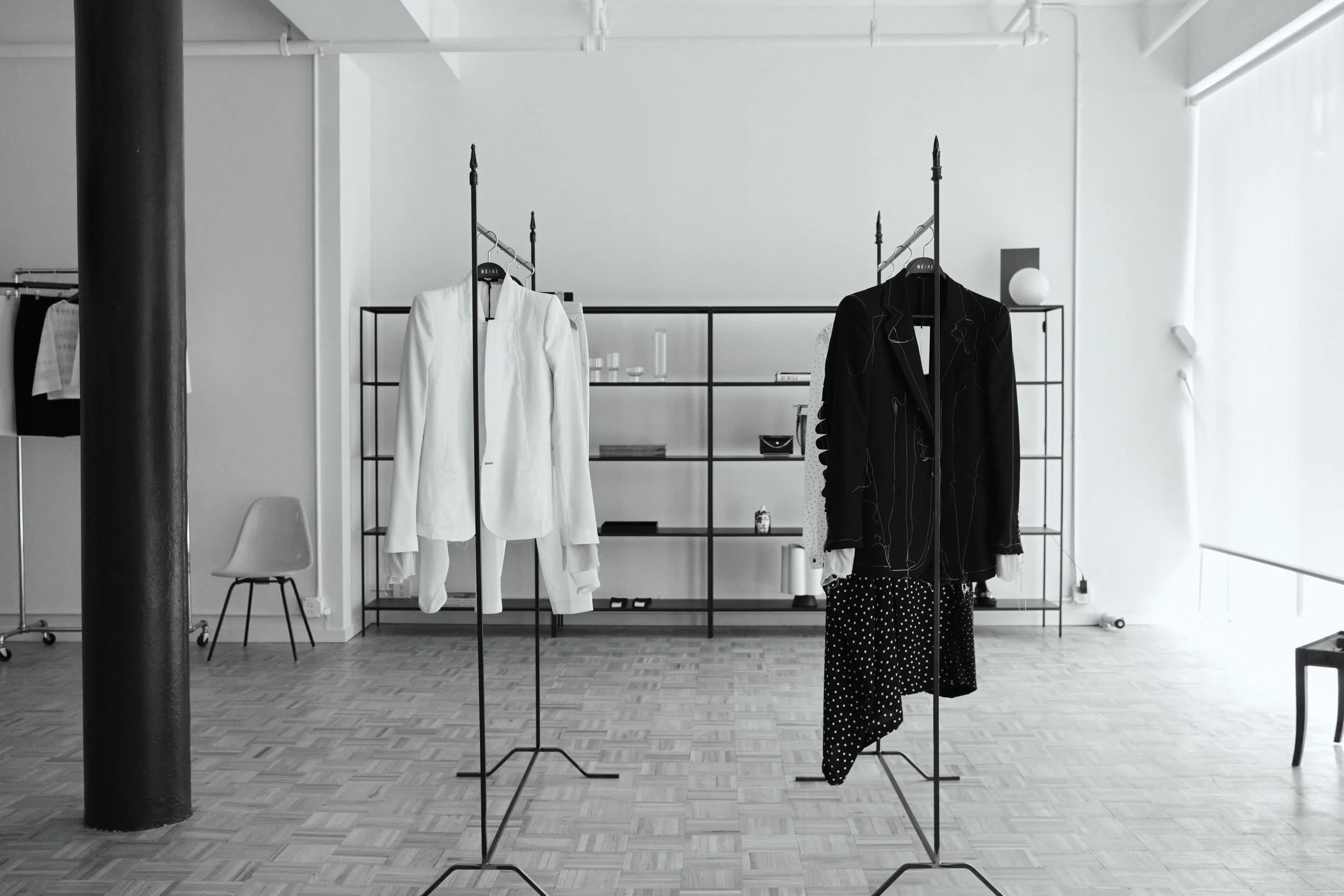 photograph of retail store re:al abayan in tribeca New York. soft elegant lighting with beautiful clothing on custom racks for showroom season durning New York fashion week. tribeca loft design