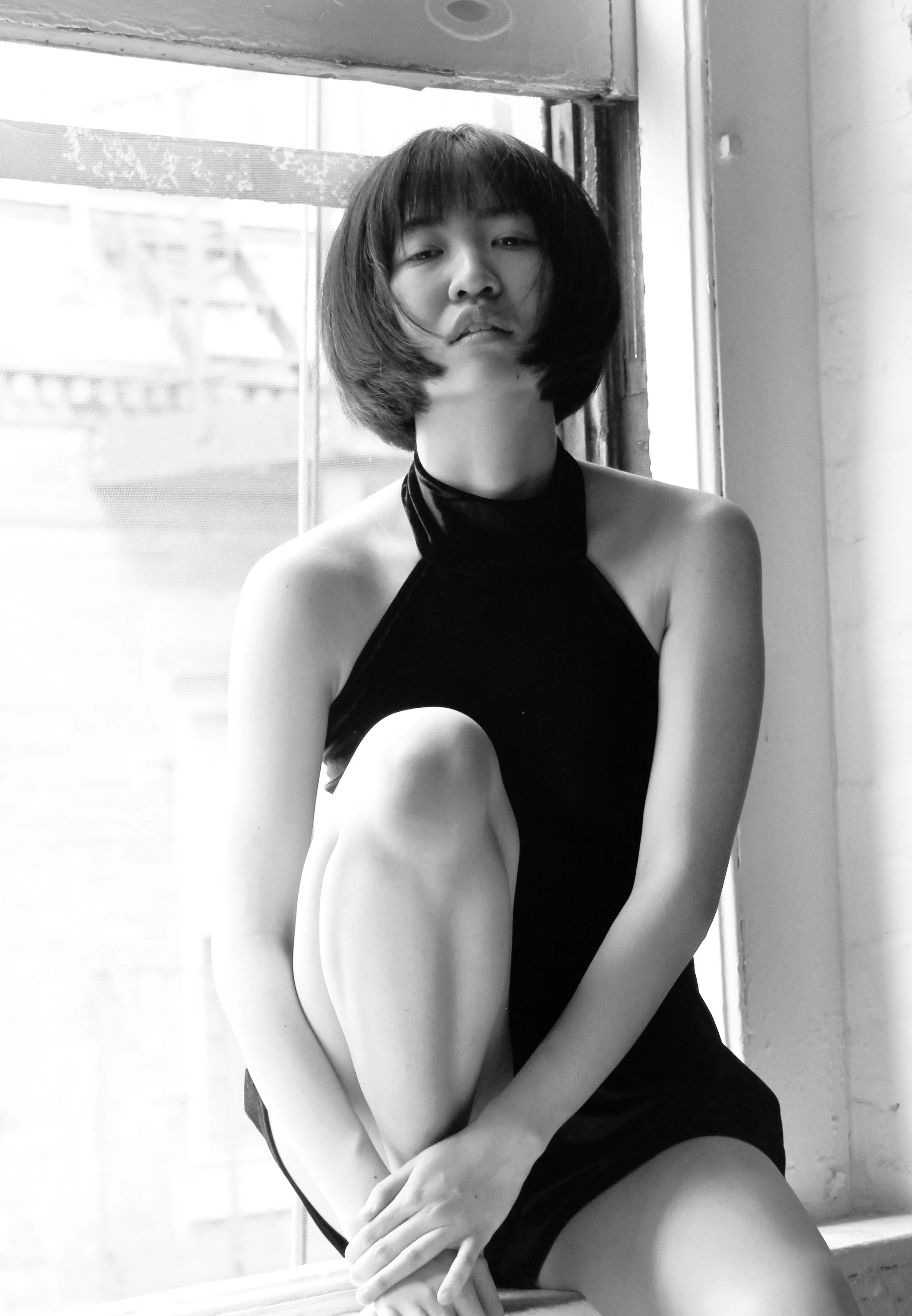 young Actress portrait photography session. sitting in the studio windows in New York City black and white back lit dreamy stylistic elegant photograph