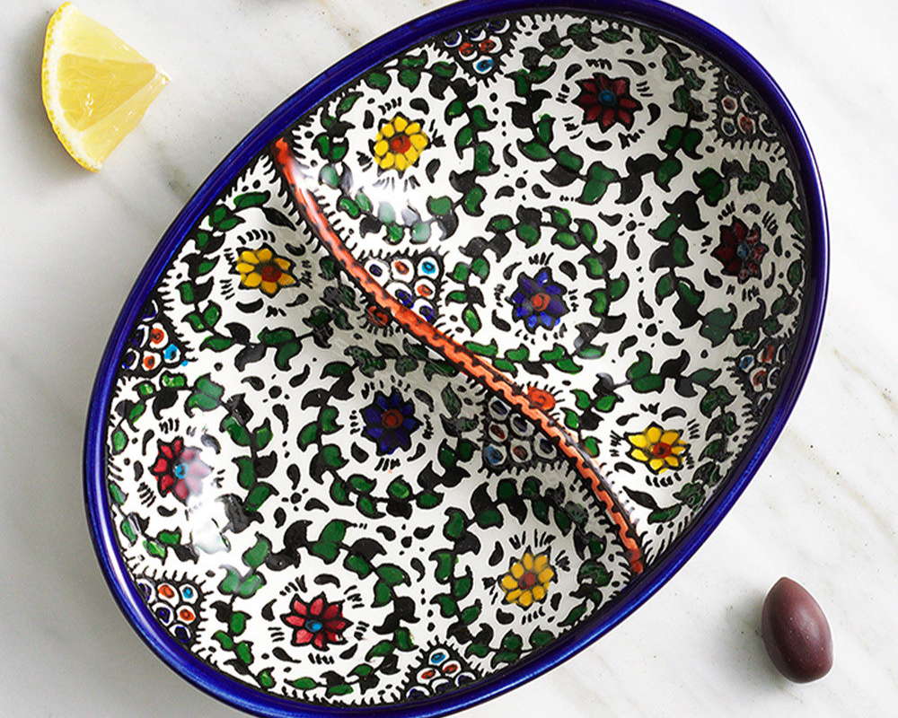A ceramic dish with a little wall in the middle, colorfully painted with flowers and leaves