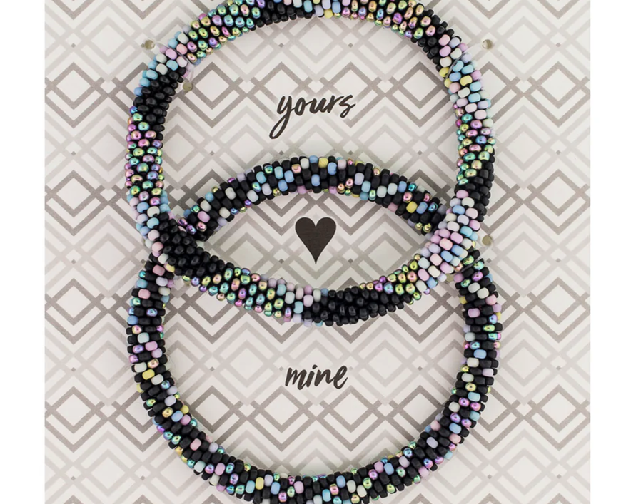 Two black bracelets speckled with pastel colors