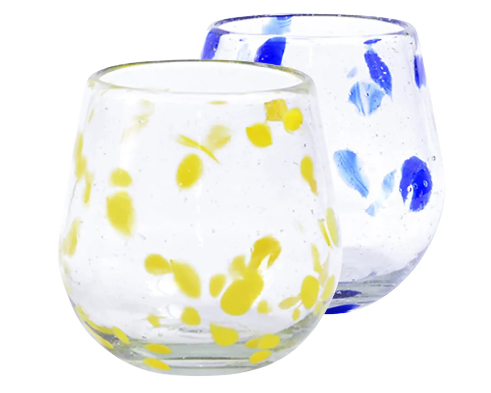 Two clear glass stemless glasses, one with blue speckles and one with yellow speckles