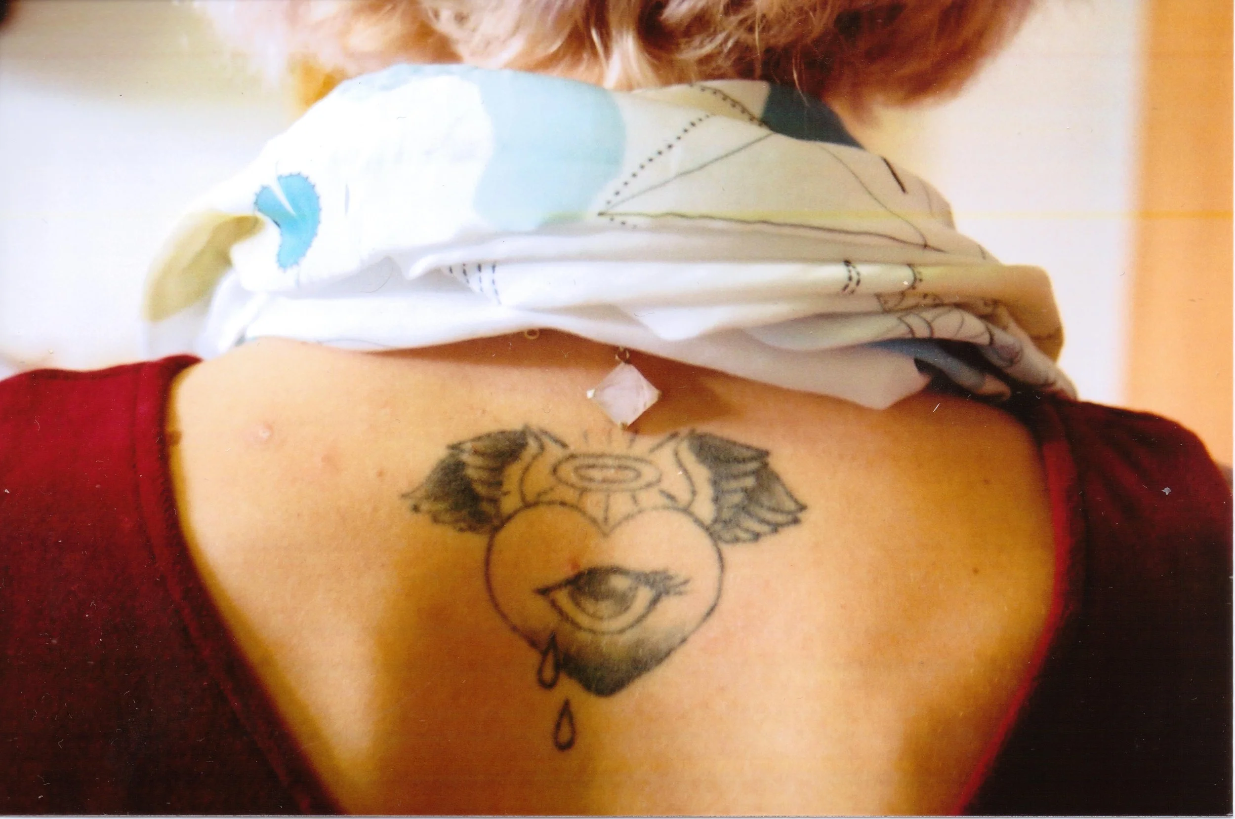 35mm-film-back-tattoo-detail-winged-heart-eye-teardrop-portrait.jpg.jpg