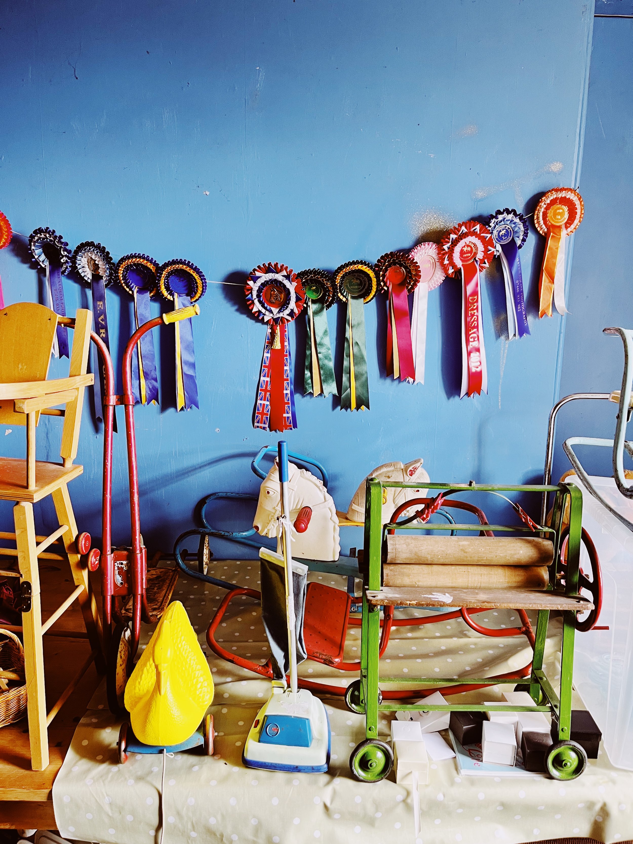 vintage-toys-and-rosettes-on-blue-wall-brighton-flea-market-display.jpg.JPEG