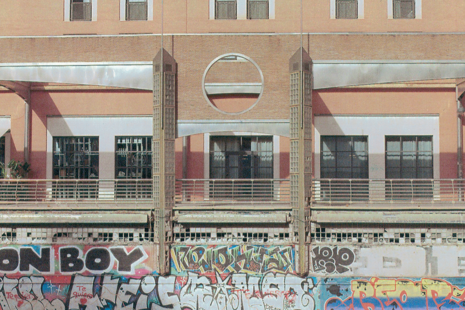 malaga-modernist-building-facade-graffiti-circular-window-35mm-film.png