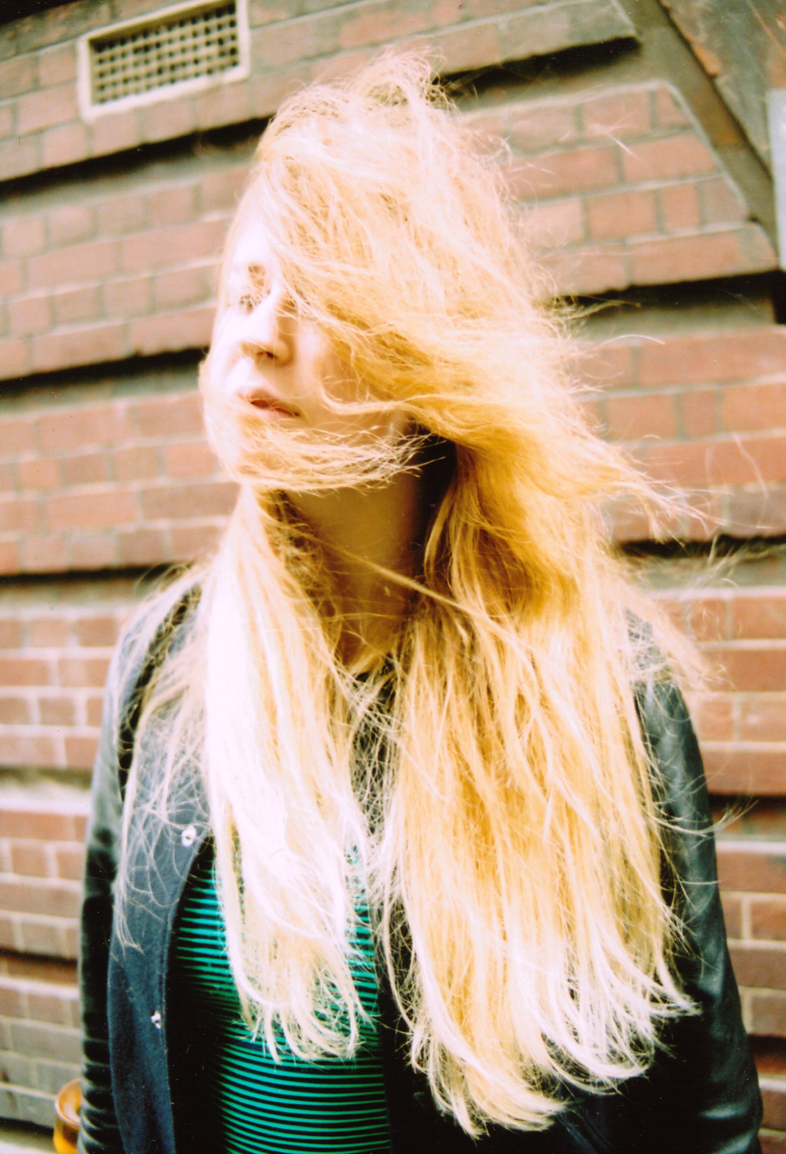 woman-with-blonde-hair-in-wind-against-brick-wall.jpg.jpg