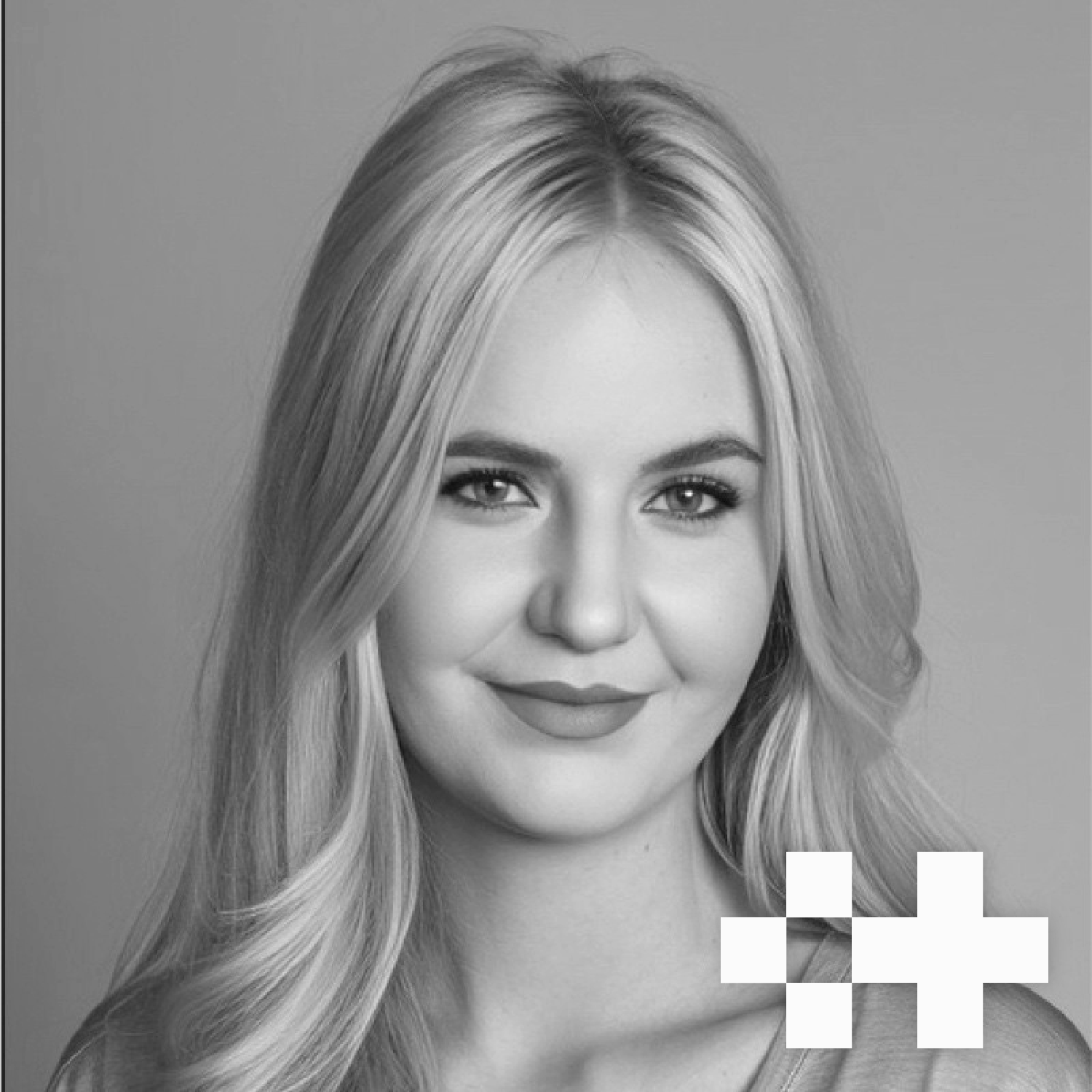 Black and white portrait of a young woman with long, wavy hair smiling at the camera.