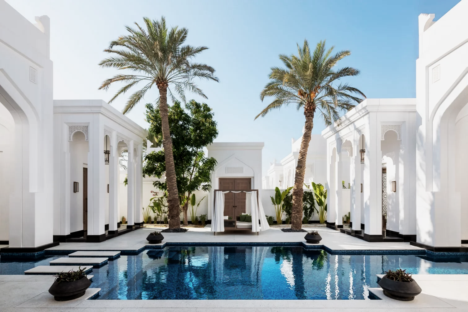 Luxury white villa with a pool, tall palm trees, and outdoor seating under a blue sky.