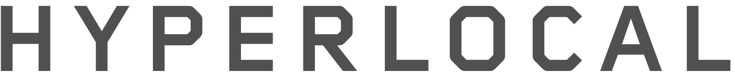 Close-up of text reading 'HYPERLOCAL' in dark gray font on a black background.
