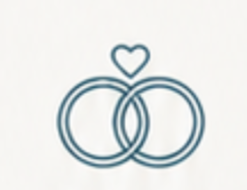 Two interlocking wedding rings with a small heart above them