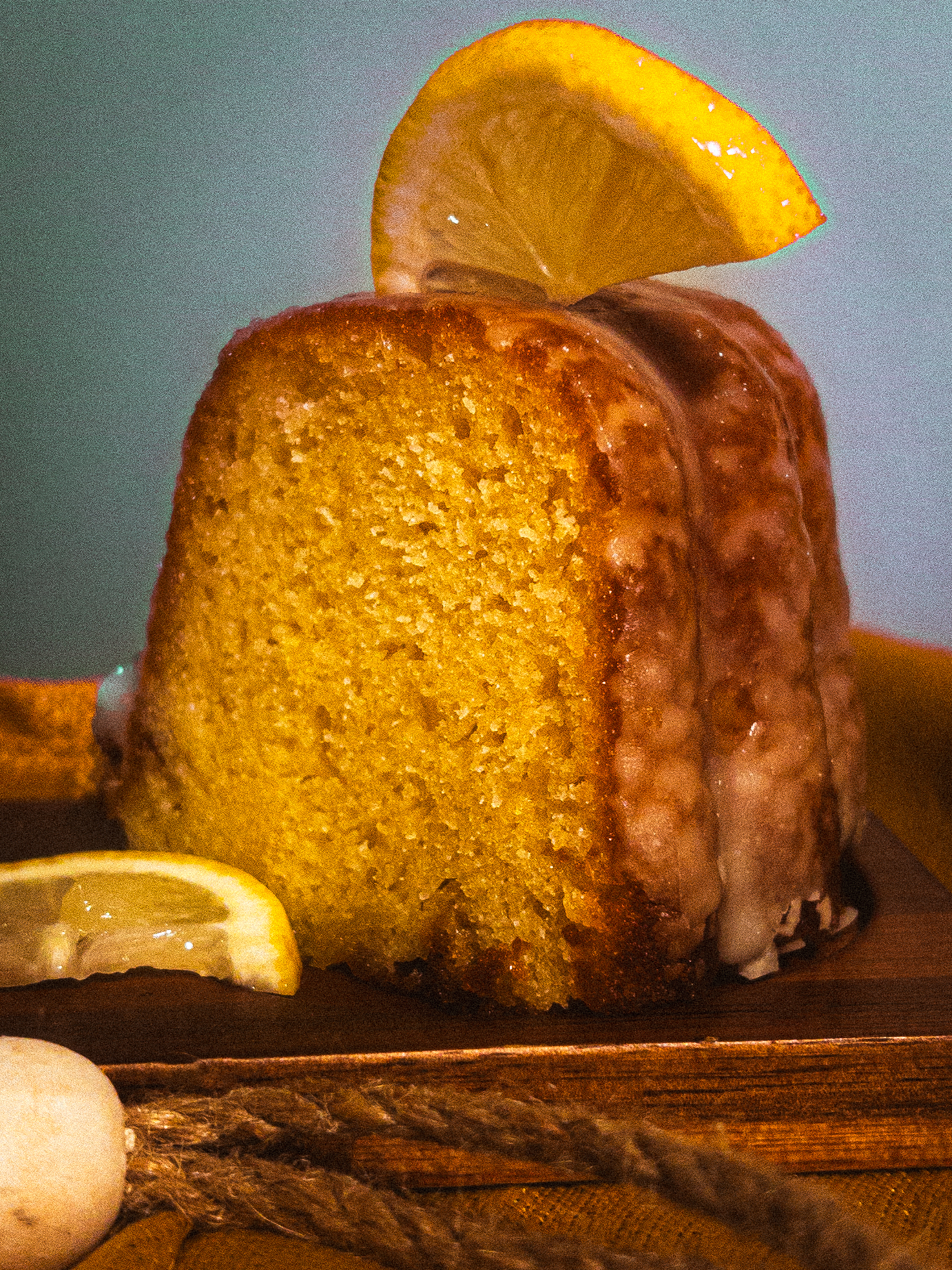 Close-up shot of a golden brown, breaded, cooked chicken breast garnished with a lemon wedge on a plate.