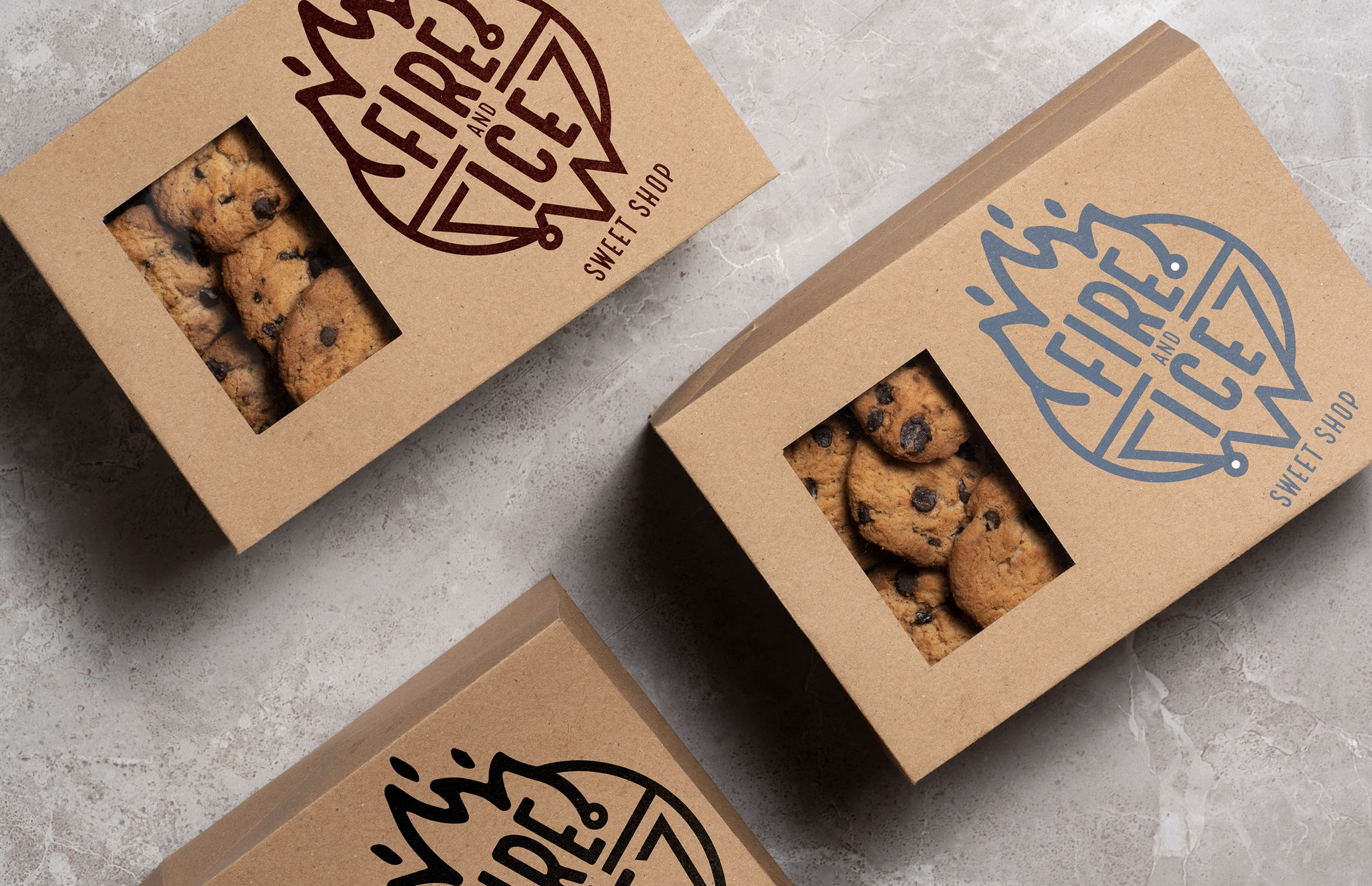 Boxes of chocolate chip cookies in kraft paper packaging with a window showing the cookies inside.