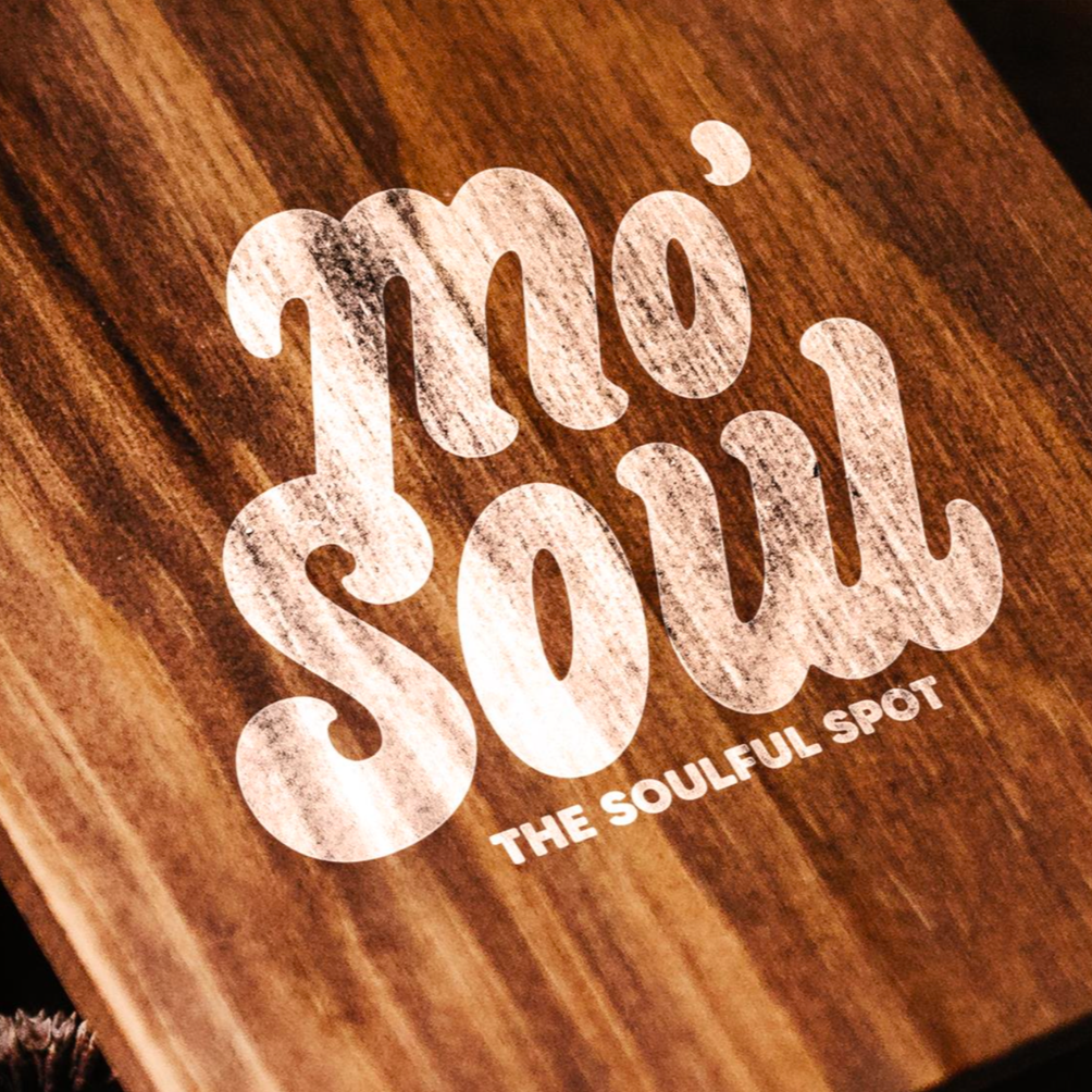 Close-up of a wooden surface with white distressed-text reading 'Moi Soi, the soulful spot'.