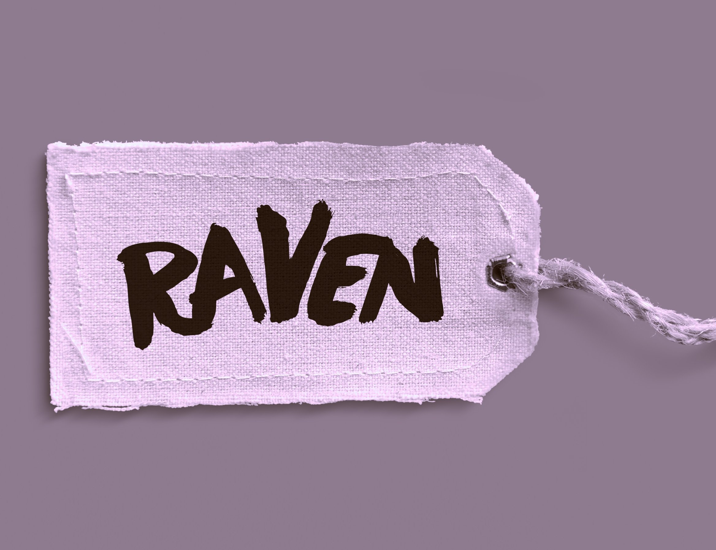 Close-up of a fabric tag with the word 'RAVE' printed in bold black letters, attached to a purple cloth with a frayed edge, against a purple background.