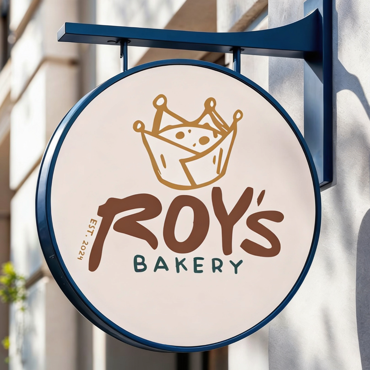 Sign for Roy's Bakery with a logo of a crown and bakery items in a bowl.
