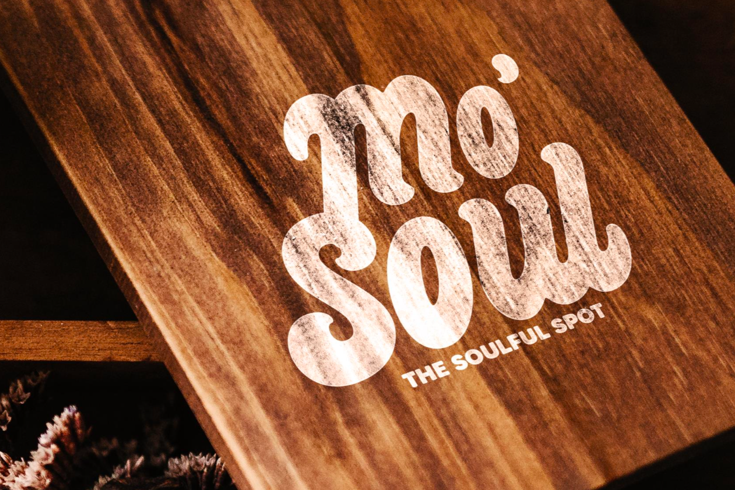 Close-up of a wooden surface with the words 'moi' and 'soul' printed in large, white, distressed font, along with the phrase 'The Soulful Spot' underneath.
