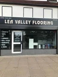  storefront of Lea Valley Flooring with signage listing services like carpets, vinyl, LVT, laminate, sheet vinyl, roll stock, accessories, and rugs.