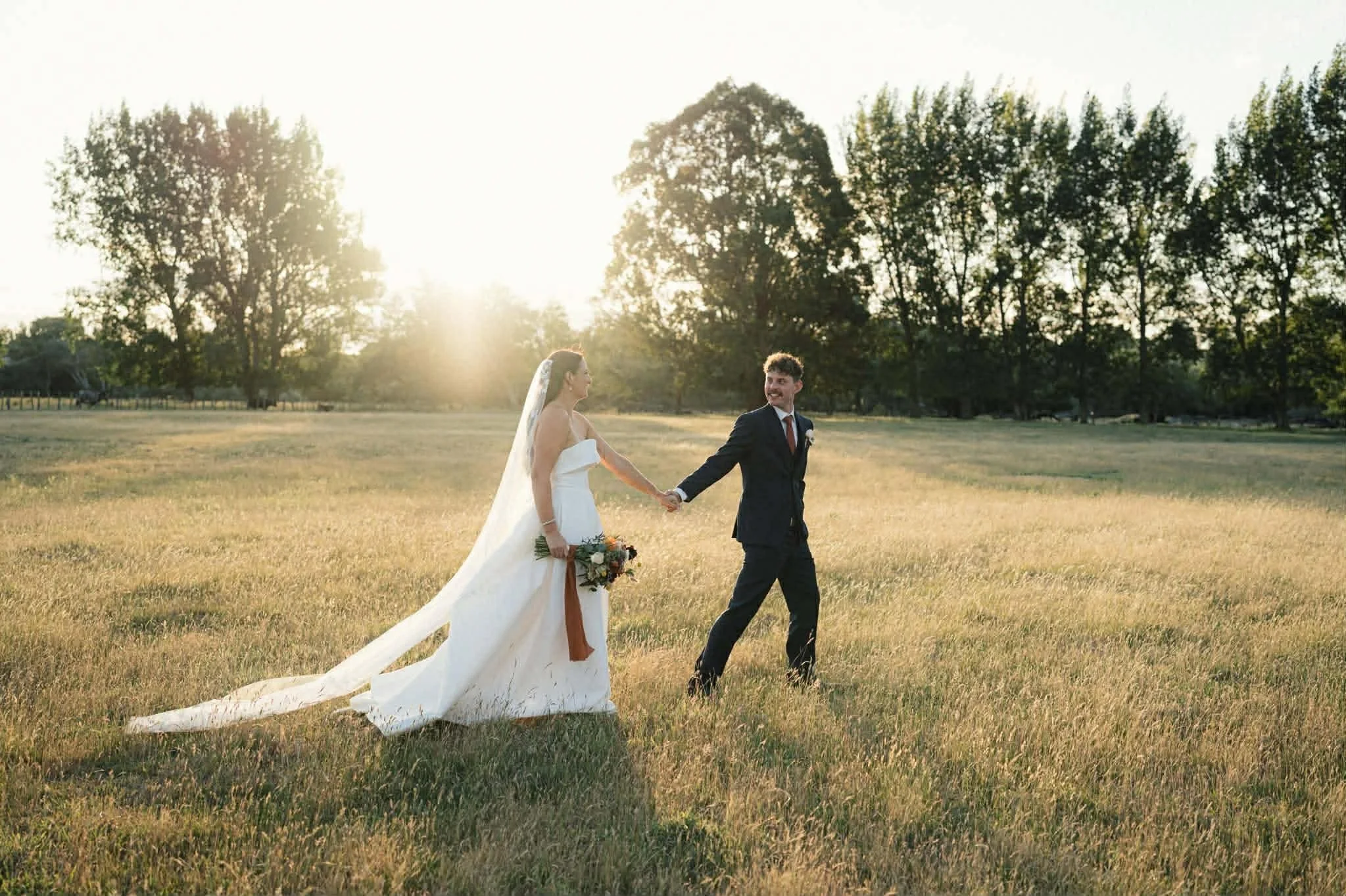Happy couple just married in field at sunset