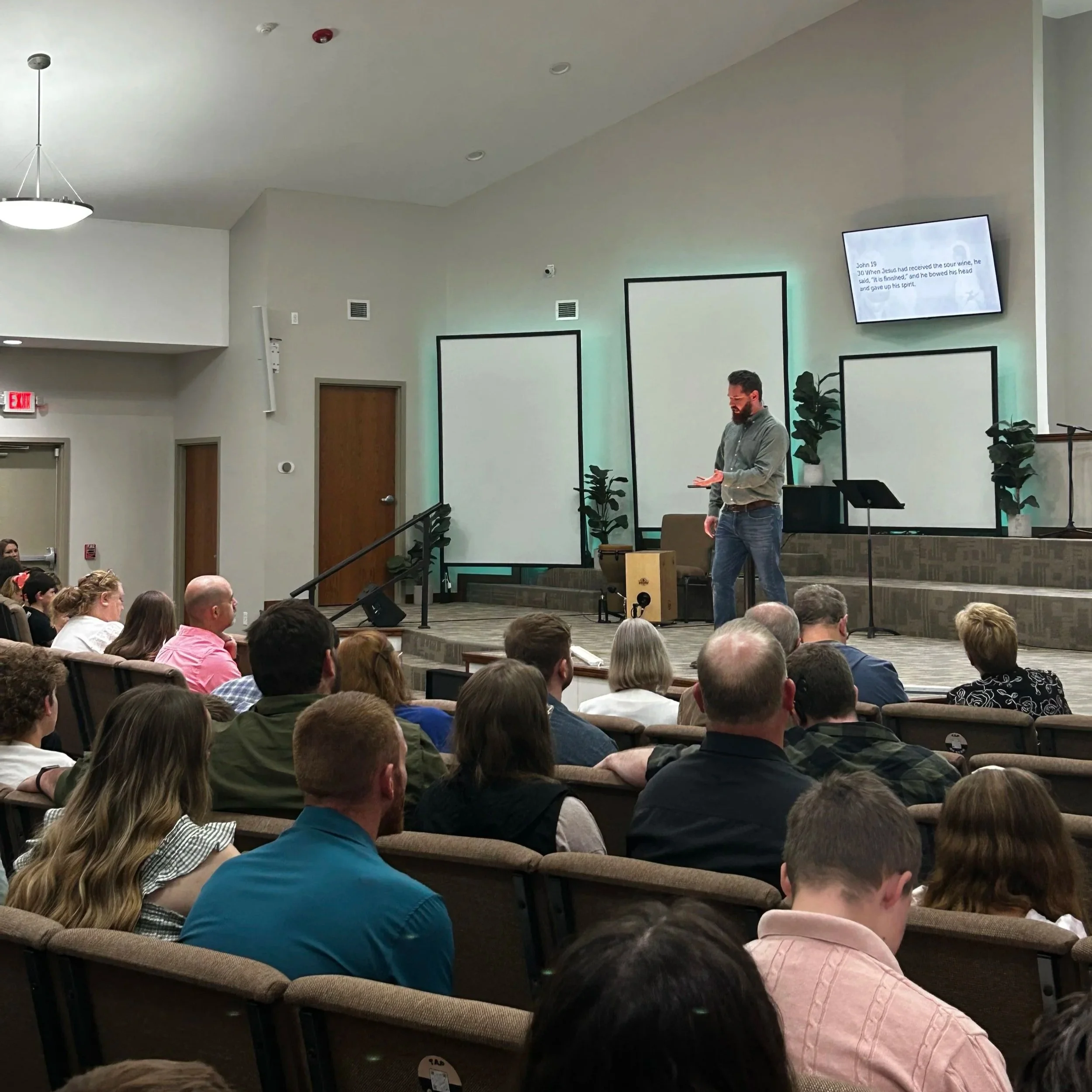 A pastor preaching to a seated congregation in the sanctuary at Solid Rock Baptist Church in Bentonville, Arkansas.
