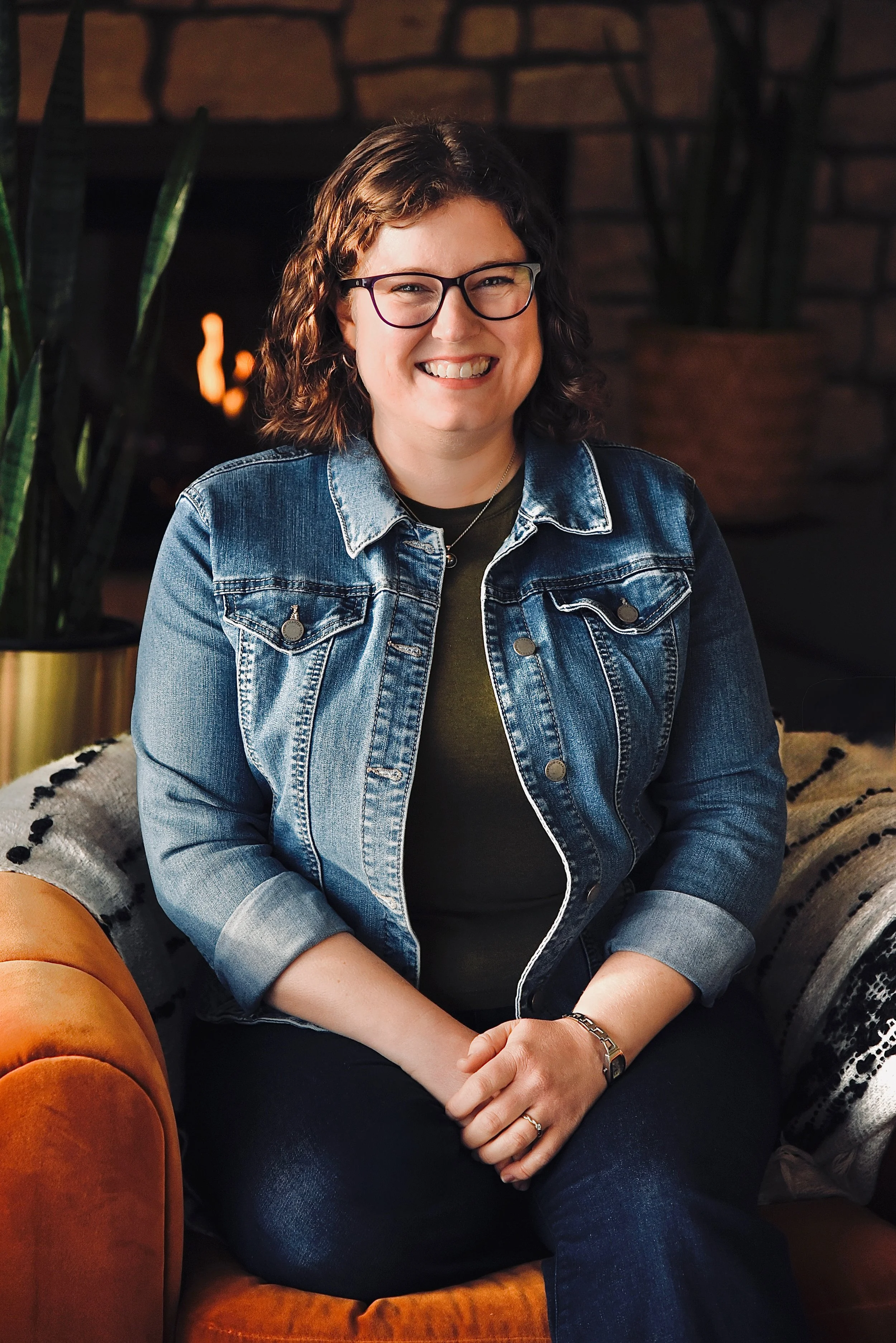 Alison, the Minnesota mom and founder behind Play Sparks Spark Boxes, smiling in a denim jacket and glasses