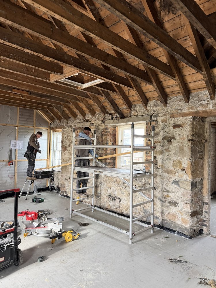 Builders renovating a stone cottage interior