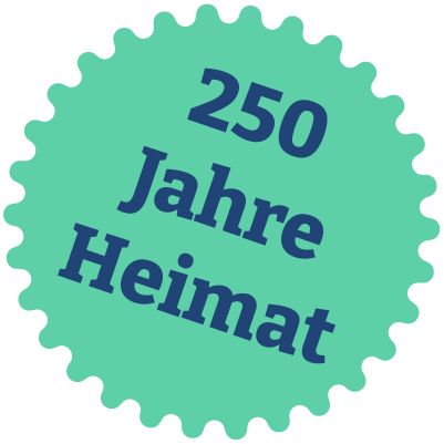 Ein grünlicherr runder Siegel mit gezacktem Rand, darauf die bläuliche Text '250 Jahre Heimat'.