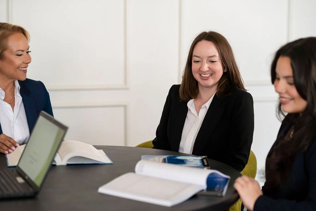 Keystone staff sitting around a table with open books and laptops discussing work material