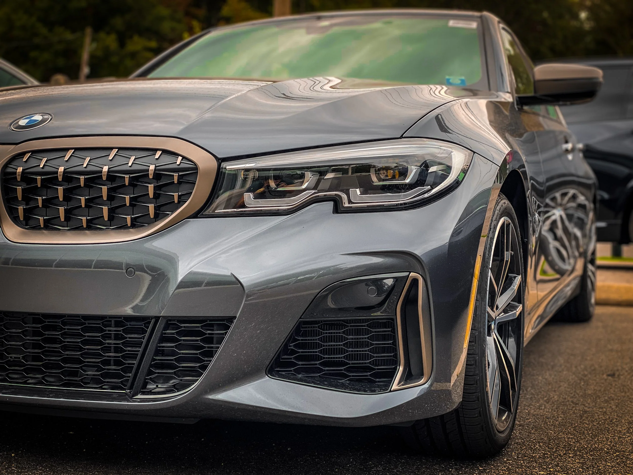 Front view of a gray BMW luxury car parked outdoors during daytime.