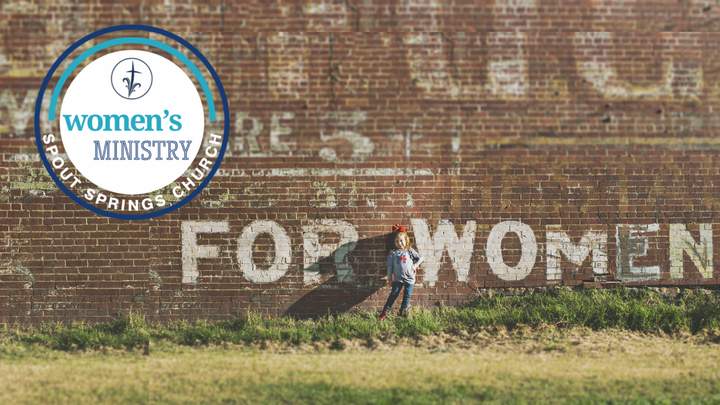 Young girl standing in front of a brick wall with the painted words 'FOR WOMEN' and a circular Women's Ministry logo from Sprout Springs Church.