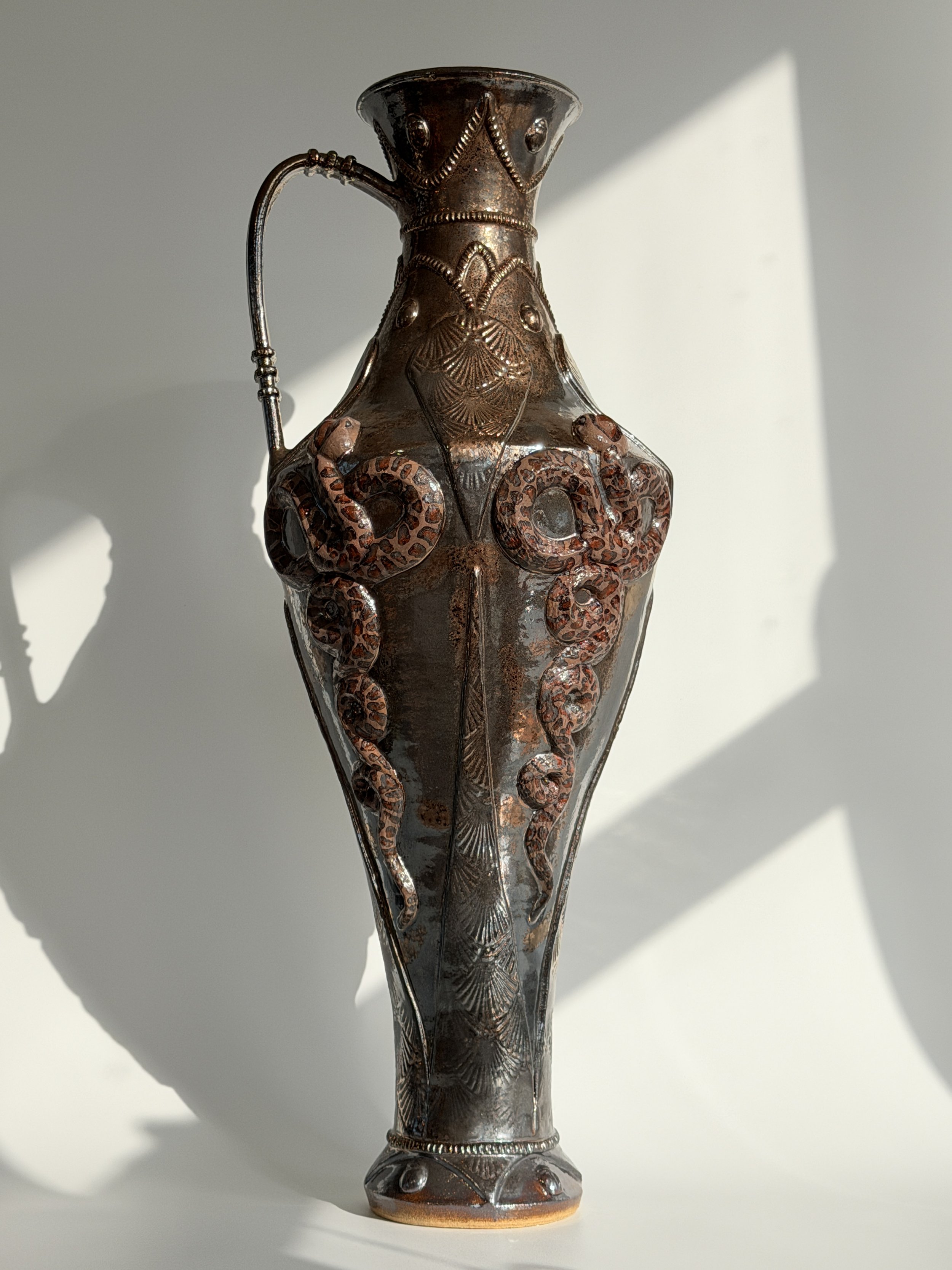 Sculptural ceramic vessel with snake reliefs, gold glaze and an antique ancient bronze vase