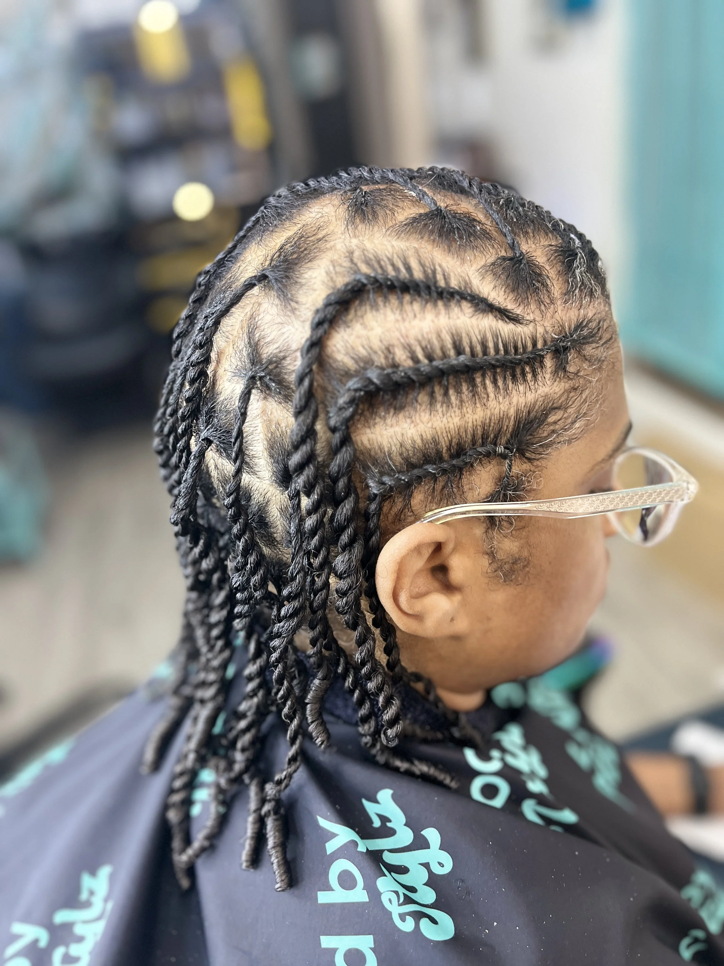 Close-up of a person's head with freshly braided hair, showcasing intricate braiding patterns and styled braids.