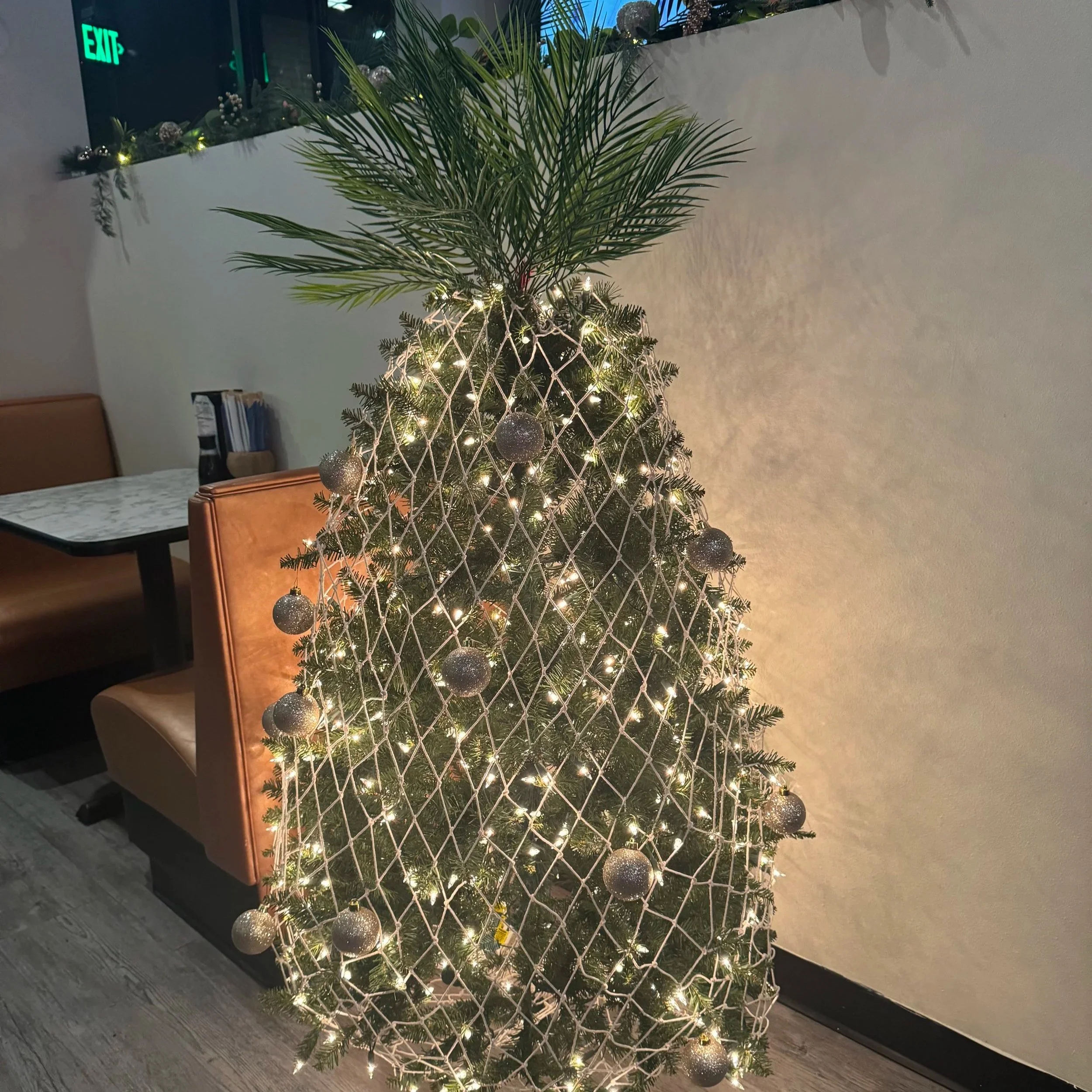 Decorated Christmas wreath with pinecones, ornaments, ribbons, and a "Merry Christmas" sign.